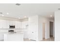 Bright, open kitchen featuring white cabinets, an island, and stainless steel appliances at 3054 Suraj Cir, Tavares, FL 32778