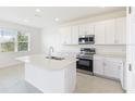 Modern kitchen featuring white cabinets, stainless appliances, and center island with a double sink at 3054 Suraj Cir, Tavares, FL 32778