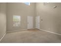 Spacious living room with neutral carpet, window and two doors at 889 Park Grove Ct, Orlando, FL 32828