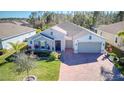 Aerial view of a beautiful single-Gathering home with well-maintained landscaping and brick-paved driveway at 840 Jasmine Creek Rd, Kissimmee, FL 34759