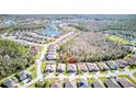 Wide aerial shot of a residential neighborhood surrounded by lush green trees and a scenic lake at 840 Jasmine Creek Rd, Kissimmee, FL 34759