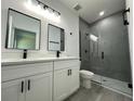 Modern bathroom features a double sink vanity with white cabinets and black hardware, plus a glass-enclosed shower at 14954 Sw 38Th Cir, Ocala, FL 34473