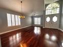 Spacious living room featuring gleaming wood floors, a decorative chandelier, and bright natural light at 1817 Baillie Glass Ln, Orlando, FL 32835