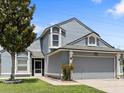 Two-story house with gray siding, landscaped yard, and a two-car garage at 302 Lakebreeze Cir, Lake Mary, FL 32746