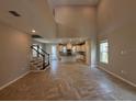Bright, open-concept living space featuring tile floors and a staircase leading to the upper level at 1227 Teal Creek Dr, Saint Cloud, FL 34771