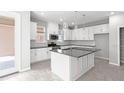 Modern kitchen with white cabinets, center island, stainless steel appliances, and gray countertops at 1231 Teal Creek Dr, St Cloud, FL 34771
