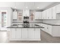 Bright, modern kitchen featuring an island, stainless appliances, white cabinets, and ample countertop space at 1231 Teal Creek Dr, St Cloud, FL 34771