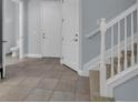 Bright entryway with tile flooring, powder room, and staircase at 10747 Belfry Cir, Orlando, FL 32832
