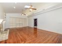 Sun-drenched living room showcases vaulted ceiling, fireplace, hardwood floors, and extensive built-in shelving at 5100 Linwood Cir, Sanford, FL 32771