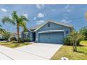 Beautiful blue single-Gathering home with a two-car garage, lush landscaping, and inviting curb appeal at 2950 Gibraltar Blvd, New Smyrna Beach, FL 32168