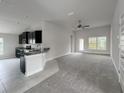 Open living room with carpet flooring and access to the kitchen at 4376 Sagefield Dr, Harmony, FL 34773