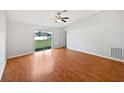 Spacious living room with hardwood floors and sliding glass doors at 7856 Habersham Dr, Lakeland, FL 33810