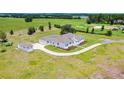 Expansive aerial view of a bright white, single-story home with a circular driveway, large lot, and separate storage shed at 9313 Quiet Ln, Winter Garden, FL 34787