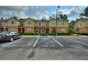 A townhome complex showing ample parking and landscaping under a partly cloudy sky at 4032 Mountain Chestnut Way, Lakeland, FL 33812