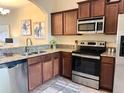 A kitchen featuring stainless steel appliances, granite countertops, and dark wood cabinets at 4032 Mountain Chestnut Way, Lakeland, FL 33812