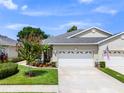 Charming home exterior featuring a two-car garage, lush lawn, and well-maintained landscaping at 118 Lower Lake Ct, Debary, FL 32713