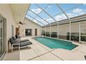 Screened-in private pool with lounge chairs and a covered patio area at 475 Windsor Pl, Davenport, FL 33896