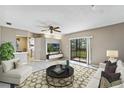 Bright living room featuring neutral tones, tile flooring, ceiling fan and slider access to balcony at 115 Springwood Cir # C, Longwood, FL 32750