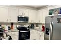 Modern kitchen with white cabinets and granite countertops at 2657 Harmonia Hammock S Rd, Harmony, FL 34773