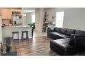 Living room features hardwood floors and L-shaped sectional sofa at 2657 Harmonia Hammock S Rd, Harmony, FL 34773