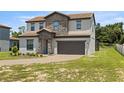 Two-story house with stone accents and landscaping at 233 Macaulay S Cv, Haines City, FL 33844
