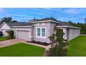 Single-story house with a two-car garage and well-manicured lawn at 3225 Stratton Cir, Kissimmee, FL 34744