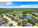 Beautiful aerial view of a residential neighborhood featuring lush greenery and a serene lake at 3872 Heirloom Rose Pl, Oviedo, FL 32766