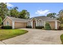 View of the attractive one story home with a 2-car garage and paved driveway at 404 Hightower Dr, Debary, FL 32713