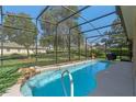Sparkling pool with a screened enclosure, waterfall feature, and lush landscaping at 404 Hightower Dr, Debary, FL 32713