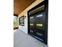 Welcoming entryway with modern black door and wood ceiling at 1102 East Pkwy, Deland, FL 32724