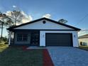 Beautiful single-story home with gray brick driveway and an attached garage at 1102 East Pkwy, Deland, FL 32724
