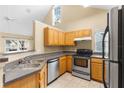 Efficient kitchen with stainless steel appliances, tile flooring, and wooden cabinetry at 3383 Westchester Square Blvd # 204, Orlando, FL 32835
