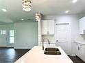 Modern kitchen featuring an island with a stainless steel sink and stylish pendant lighting at 1310 Tallahassee Ct, Poinciana, FL 34759