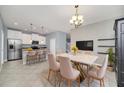 Open dining area featuring a modern light fixture, large kitchen island with breakfast bar, and neutral color palette at 7642 Fairgrove Ave, Windermere, FL 34786