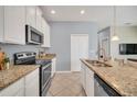 Bright kitchen with stainless steel appliances, granite countertops, and white cabinets at 7642 Fairgrove Ave, Windermere, FL 34786
