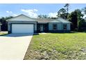 Beautiful home with a well-manicured lawn, long driveway, and an attached garage at 1209 Alafia Way, Poinciana, FL 34759