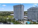 Exterior shot featuring a high-rise building, a pool, and green landscaping at 13427 Blue Heron Beach Dr # 405, Orlando, FL 32821