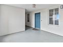 A bright hallway featuring a blue door, neutral walls and floor, with natural light at 13427 Blue Heron Beach Dr # 405, Orlando, FL 32821