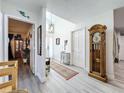Bright entryway featuring hardwood style flooring, a tall clock, and a view to other rooms in the home at 4316 Natchez Trace Dr, St Cloud, FL 34769