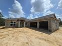 New construction exterior featuring concrete walls, attached two car garage, and a covered front entry way at 13455 Sw 85 Pl, Dunnellon, FL 34432