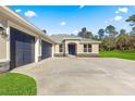 Three-car garage and front entrance of new home at 13455 Sw 85 Pl, Dunnellon, FL 34432