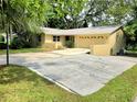A single Gathering home with a very large drive way leading to an attached garage and a manicured lawn at 425 E Hillcrest St, Altamonte Springs, FL 32701