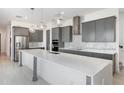 Modern kitchen features a large island, stainless steel appliances and elegant gray cabinetry at 10266 Beechwood Ln, Orlando, FL 32832
