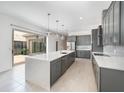 Spacious kitchen featuring stainless appliances, a large island and sliding doors to the outside at 10266 Beechwood Ln, Orlando, FL 32832