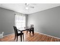 Inviting dining room featuring a ceiling fan, grey walls, and a dark wood table set for two at 2495 Sedgefield Ave, Deltona, FL 32725