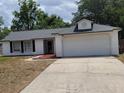 Charming one-story home featuring a two-car garage, white siding, black shutters, and a well-maintained front lawn at 2495 Sedgefield Ave, Deltona, FL 32725