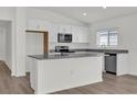Modern kitchen featuring white cabinetry, stainless steel appliances, and granite countertops at 5577 Creek Haven Way, Lakeland, FL 33810