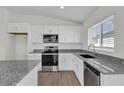 Bright kitchen featuring white cabinets, stainless steel appliances, granite countertops, and modern fixtures at 5577 Creek Haven Way, Lakeland, FL 33810