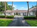 Expansive home exterior with a tile roof, arched windows, mature trees, and a circular driveway at 1306 Sweetwater Club Blvd, Longwood, FL 32779