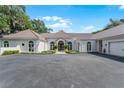 Home exterior featuring a tile roof, arched windows, circular driveway and lush landscaping at 1306 Sweetwater Club Blvd, Longwood, FL 32779